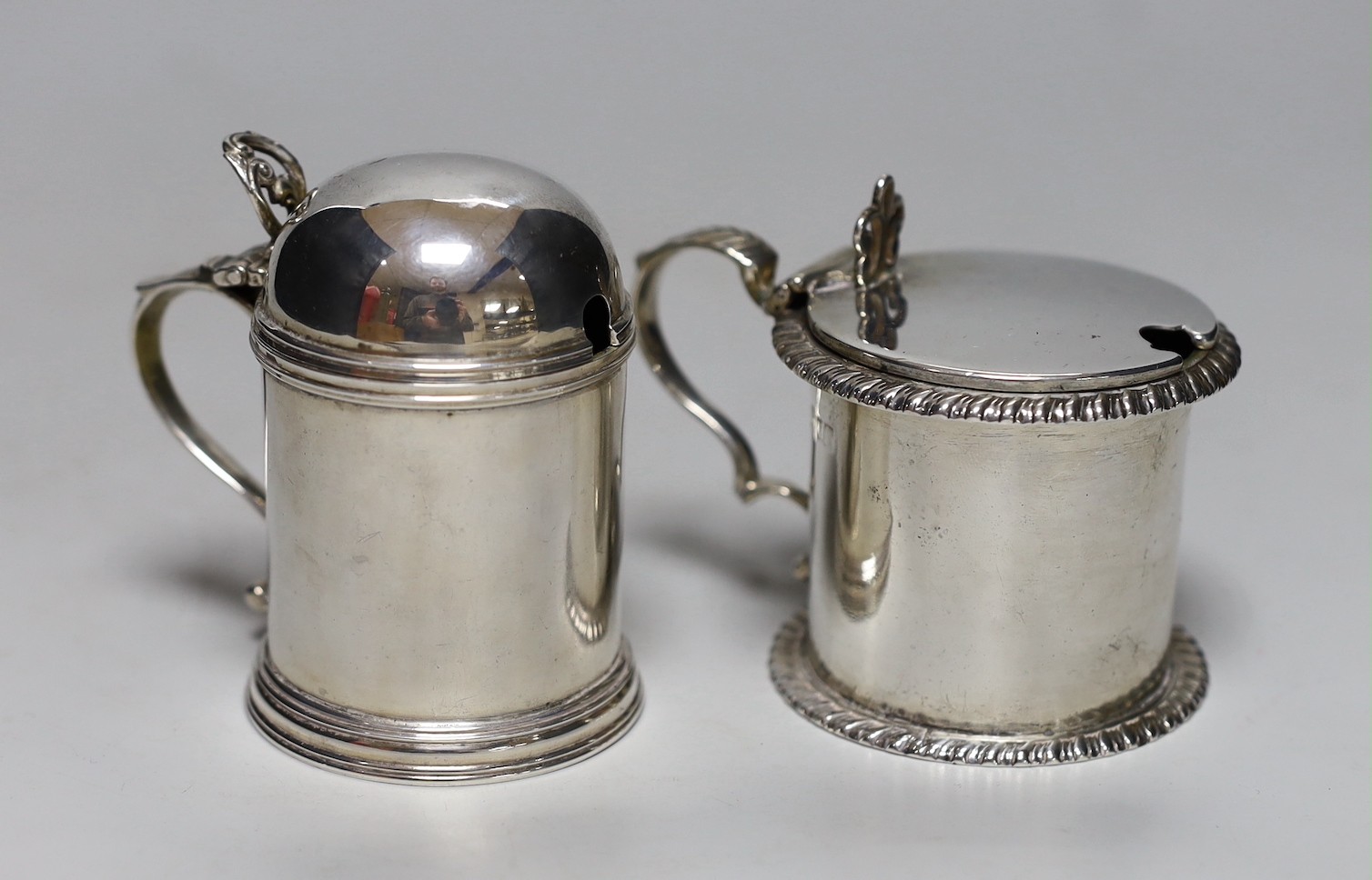 A late Victorian silver dome topped mustard pot, Josiah Williams & Co, London, 1897, height 8cm and an Edwardian silver drum mustard, London, 1902, 8.1oz, both with glass liners, one associated.
